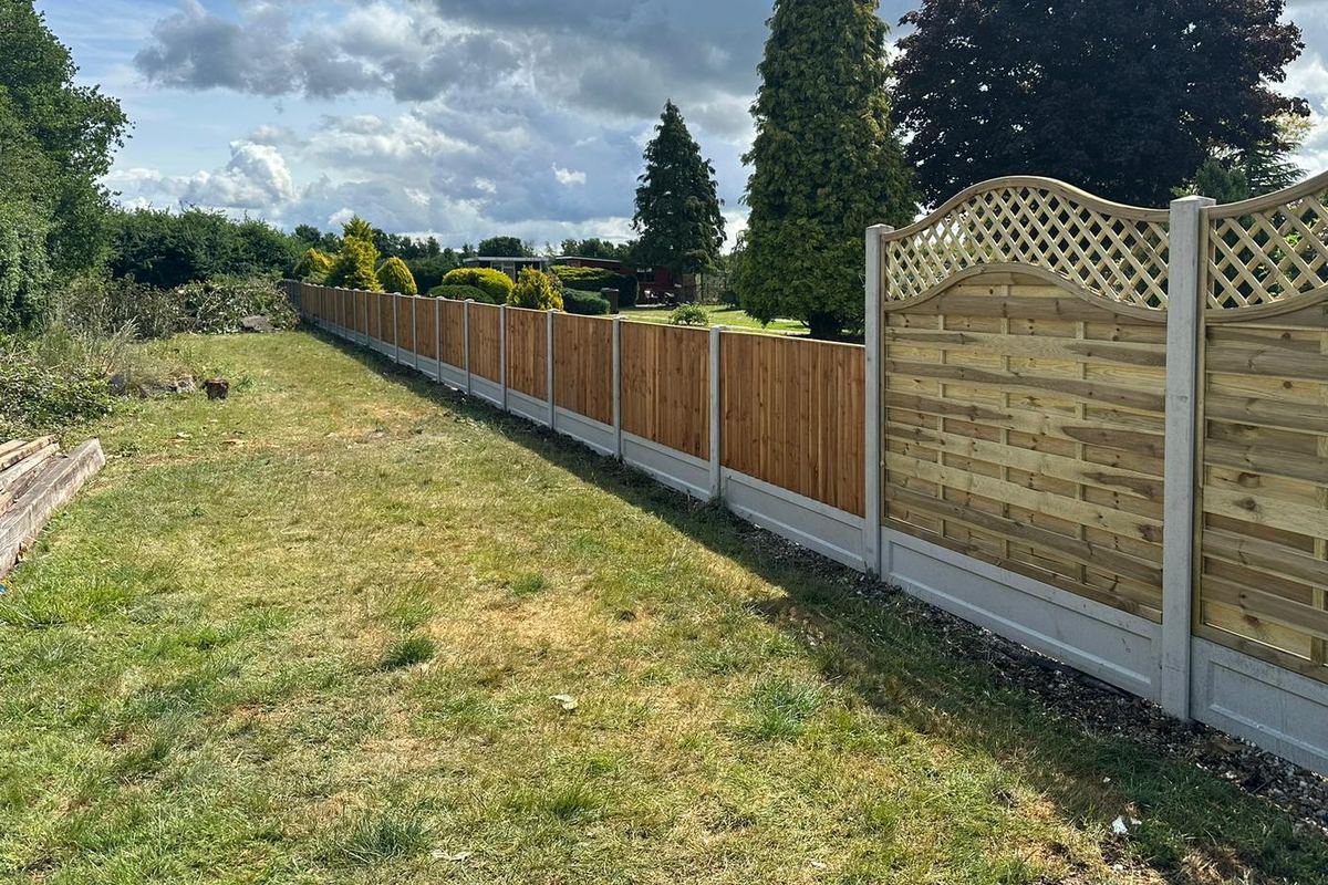 The same boundary after work: new closeboard panels and wave-top trellis on concrete posts