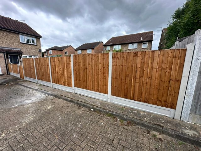 New closeboard fencing on concrete posts and gravel boards beside a block-paved drive
